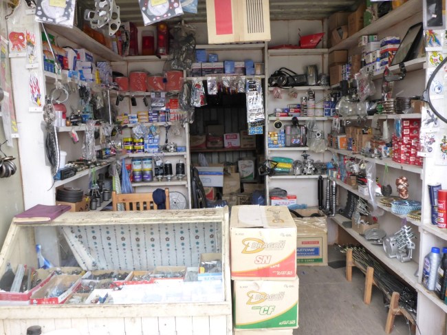 A container display of car and bike spares, including worm drive clips.