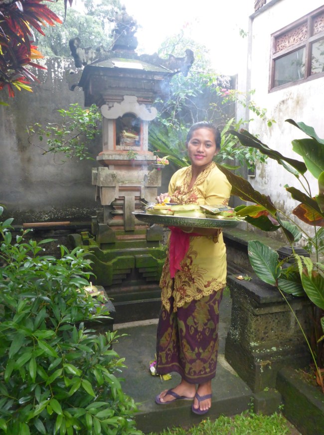Komang takes the morning offerings to the shrine.