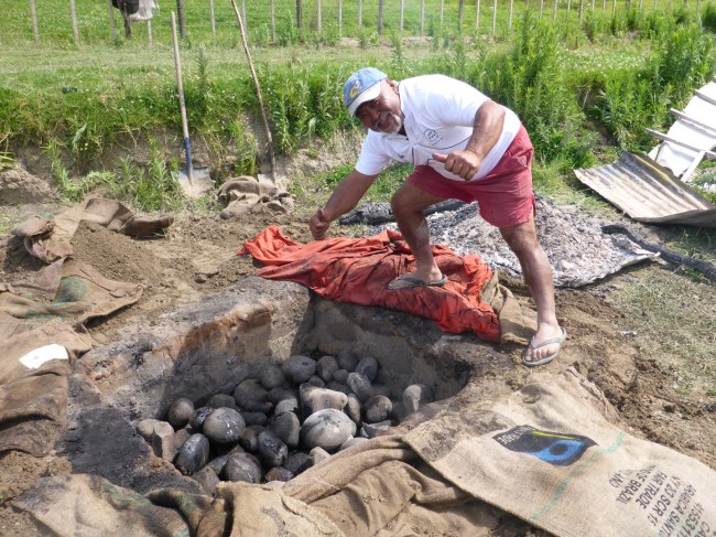 Len opens up the cooking pit.